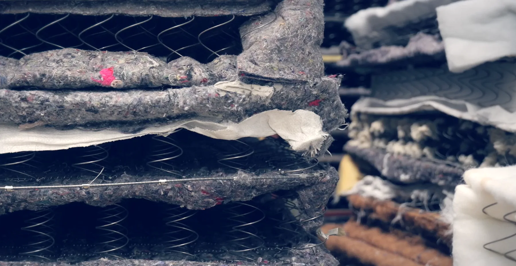 Workers separating mattress materials for recovery