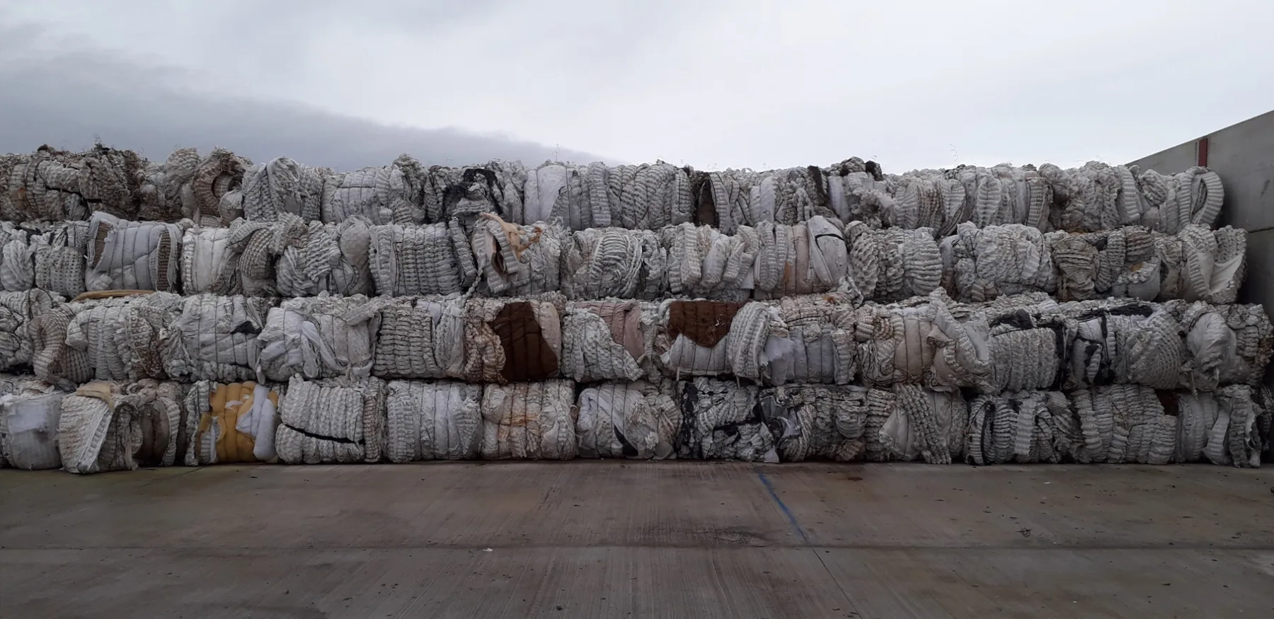 Rows of compressed textile and mattress fibre bales